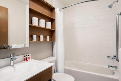 a bathroom with a toilet and a sink and a tub at Microtel Inn & Suites by Wyndham Val-d Or in Val-dʼOr