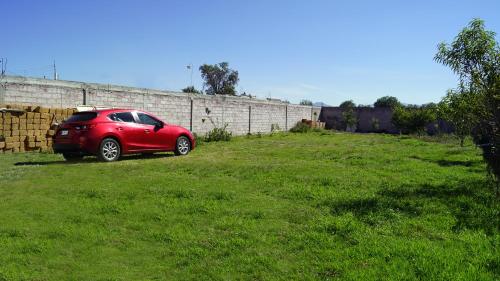a red car parked in a grass field at Hotel Boutique Tonalli in San Martín de las Pirámides