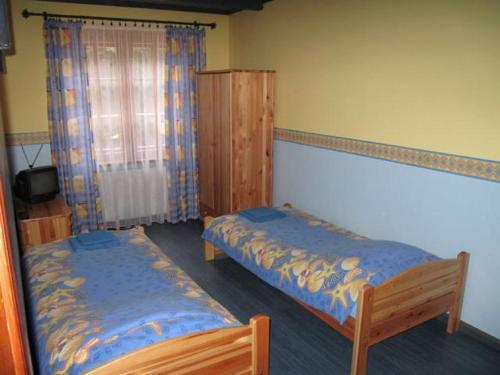 sypialnia z 2 łóżkami i oknem w obiekcie Szypry - wakacyjny dom nad jeziorem w mieście Barczewo