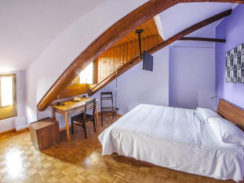 a bedroom with a bed and a table and a staircase at Artua'&Solferino in Turin