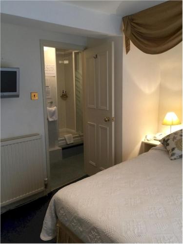 a bedroom with a bed and a bathroom with a shower at Bath Place Hotel in Oxford