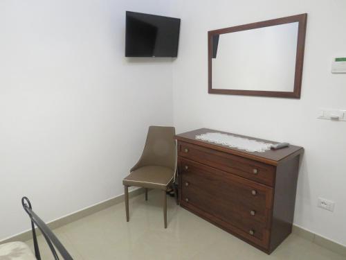 a room with a dresser and a chair and a mirror at Casa Rita in Manduria