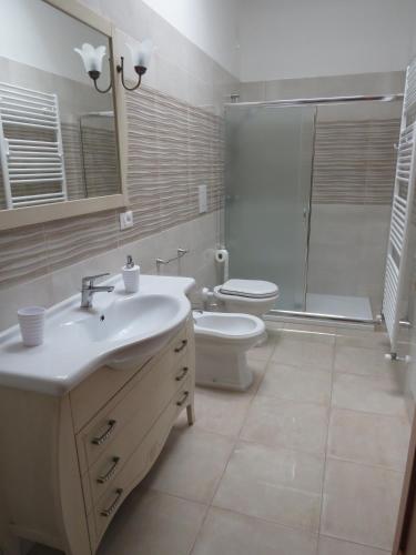 a bathroom with a sink and a toilet and a shower at Casa Rita in Manduria
