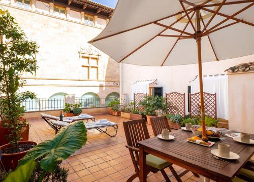 een patio met een tafel en een parasol bij Ramón Llull House in Palma de Mallorca