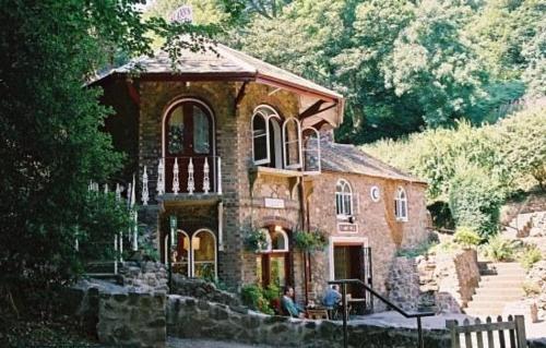 a large brick house with people sitting in front of it at By the Way in Great Malvern