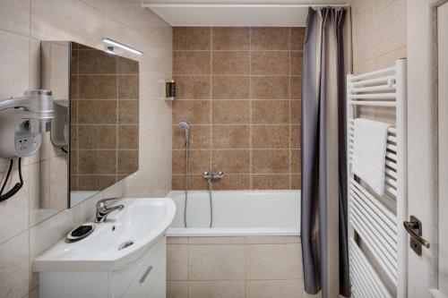 a bathroom with a sink and a bath tub at Louren Apartments in Prague