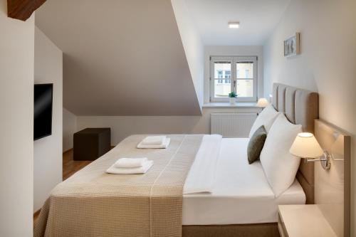 ein Schlafzimmer mit einem großen Bett mit zwei Handtüchern darauf in der Unterkunft Louren Apartments in Prag