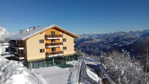a building on top of a snow covered mountain at Hotel Monte Bondone in Vaneze