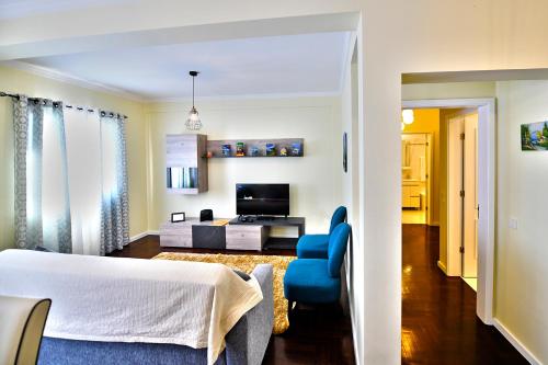 a bedroom with a bed and a blue chair at Sol & Mar Camara de Lobos in Câmara de Lobos