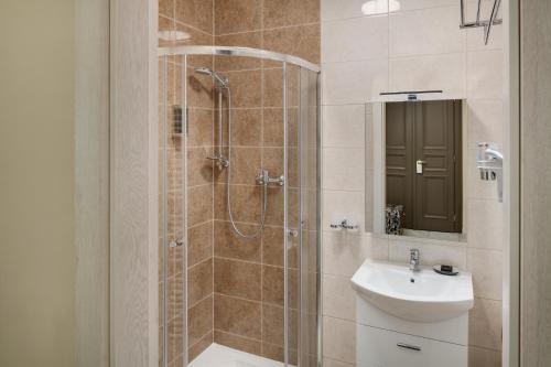 a bathroom with a shower and a toilet and a sink at Louren Apartments in Prague