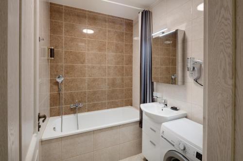 a bathroom with a tub and a sink and a toilet at Louren Apartments in Prague