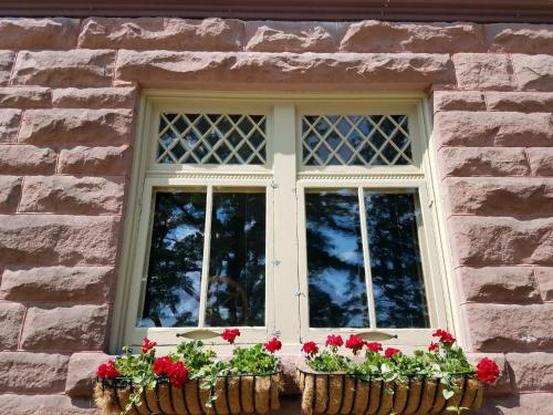 a window with flowers in baskets on a stone building at Pinehurst Inn Bed & Breakfast in Bayfield