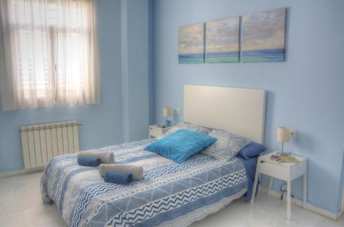 een blauwe slaapkamer met een bed met blauwe kussens bij SEVILLA BUTTERFLY SUITES in Sevilla