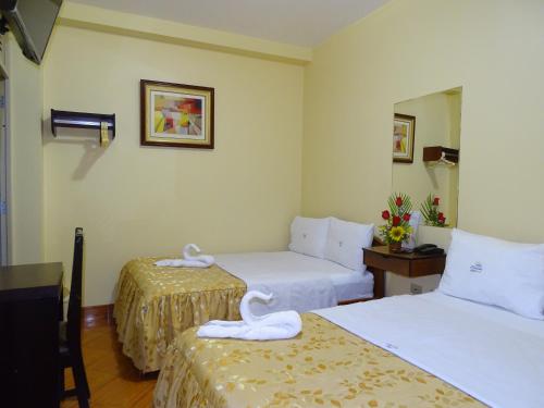 a hotel room with two beds with towels on them at Hotel Primavera in Chiclayo