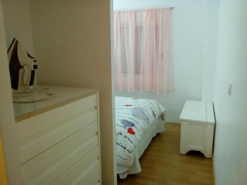 sypialnia z łóżkiem, komodą i oknem w obiekcie Apartamentos pandiellos I w Madrycie