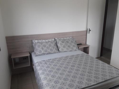 1 dormitorio con 1 cama grande y 2 almohadas en Ap Praia Morro - 350m Mar, en Guarapari