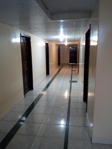 an empty hallway with doors and a tile floor at Hostal Buenaventura Ibarra in Ibarra