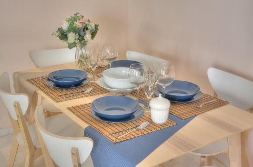 a wooden table with blue plates and wine glasses at SEVILLA BUTTERFLY SUITES in Seville