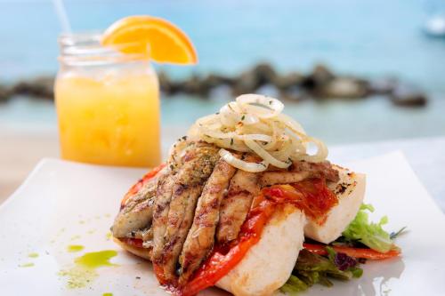 a piece of fish on a plate with a drink at Little Good Harbour in Saint Peter