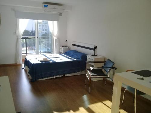 1 dormitorio con cama, escritorio y ventana en Apart Delacroix en Santa Fe