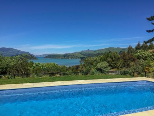 a swimming pool with a view of a lake at Twin Gullies in Akaroa