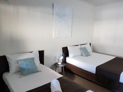 En eller flere senge i et værelse på Coral Sands Motel