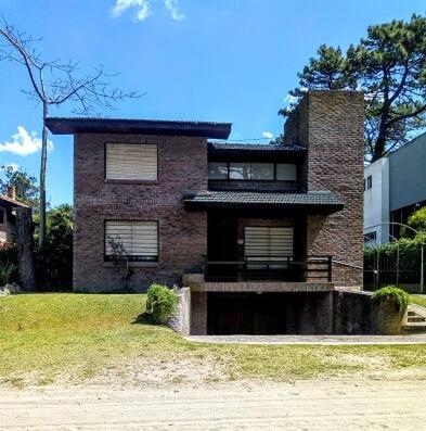 una casa de ladrillo sentada sobre un campo de hierba en Texas Verdes Alojamiento Familiar en Villa Gesell