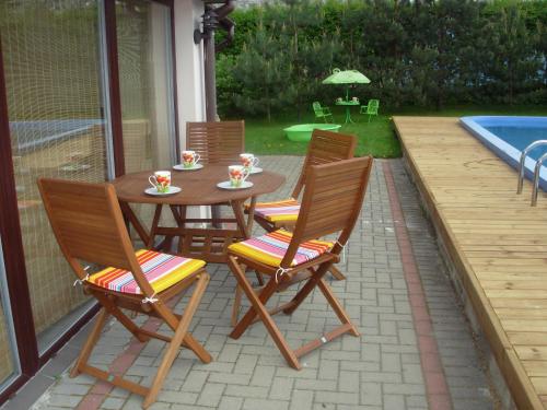 a patio with a table and chairs and a pool at Svečiuose pas Arvydą in Klaipėda