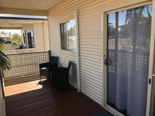 a balcony with a table and chairs on it at The Sundowner Cabin & Tourist Park in Whyalla