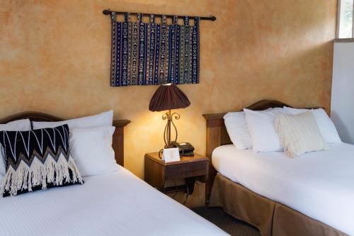 two beds sitting next to each other in a room at Hotel Ciudad Vieja in Guatemala