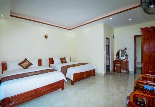 a bedroom with two beds and a mirror at Ngoc Lan Hotel in Cao Bằng