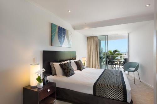 a hotel room with a bed and a balcony at at Marina Shores in Airlie Beach