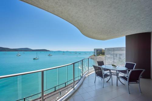 a balcony with a table and chairs and a view of the water at at Marina Shores in Airlie Beach
