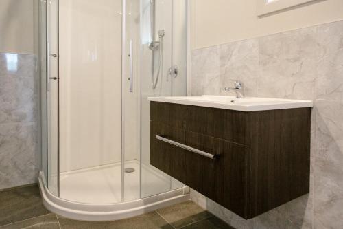 La salle de bains est pourvue d'un lavabo et d'une douche. dans l'établissement Sunset Motel, à Thames