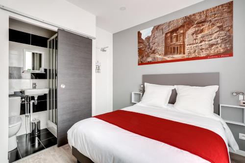 a bedroom with a large bed and a bathroom at Paris Hotel in Clichy