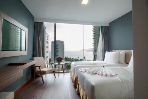 a bedroom with a large bed with a large window at Libra Hotel Nha Trang in Nha Trang