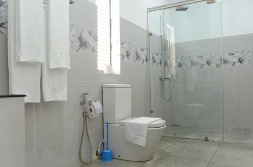 a bathroom with a toilet and a glass shower at Single Fin Weligama in Weligama