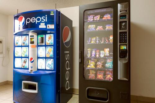 a cocacola vending machine next to a drink cooler at Motel 6-Albert Lea, MN in Albert Lea