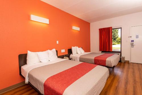 two beds in a room with orange walls at Motel 6-Kingsport, TN in Kingsport