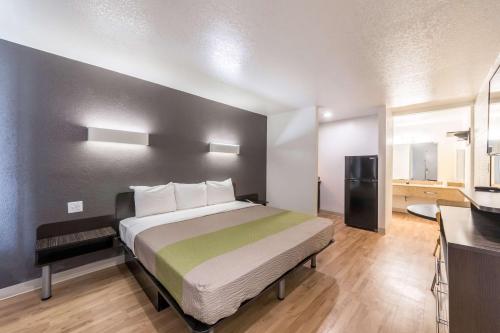a bedroom with a large bed and a kitchen at Studio 6-San Antonio, TX - Fort Sam Houston Area in San Antonio