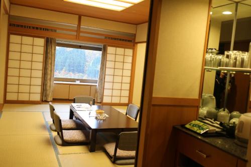 a room with a table and chairs and a window at NASPA New Otani in Yuzawa