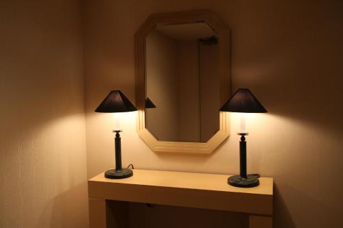 two lamps on a table in a bathroom with a mirror at NASPA New Otani in Yuzawa