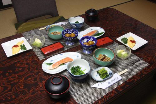 
a wooden table topped with bowls of food at Yamada-ya Ryokan in Nozawa Onsen
