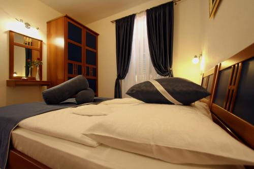 a bedroom with a large bed with two pillows at Apartments AMORE in Bol