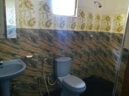 a bathroom with a toilet and a sink at Coco Garden Holiday Homes in Anuradhapura