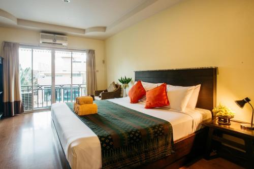 a bedroom with a large bed and a balcony at Diamond Park Inn Chiangrai & Resort in Chiang Rai