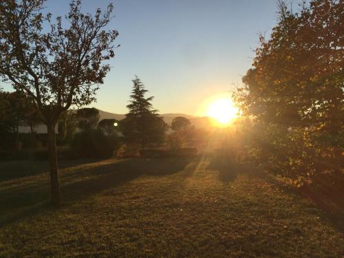a sun setting over a field with trees at Villa Giulia in Avezzano