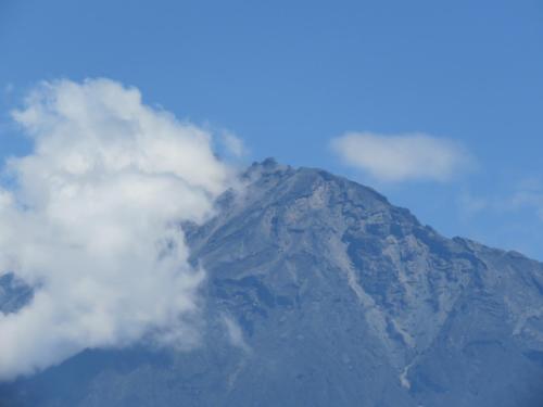 a mountain covered in clouds in front at Boulevard Inn Mt Meru in Arusha