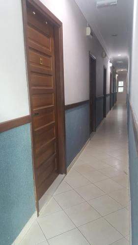a hallway with a wooden door and a tile floor at HOTEL SHAFURA 1 in Cukai