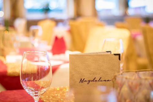 a table with a glass of wine and a menu at Hotel Magdalena im Zillertal - Urlaub mit Hund in Ried im Zillertal